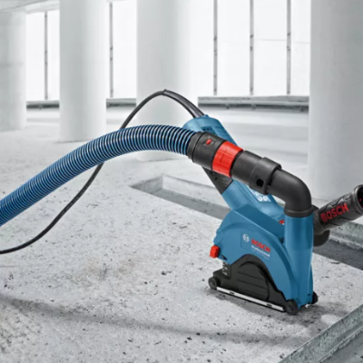 Máquina de corte Bosch azul com tubo flexível azul em ambiente industrial