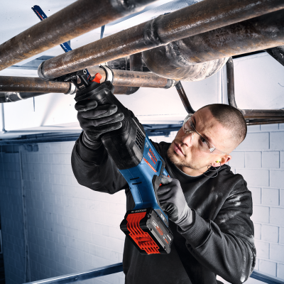 Pessoa a usar serra tico-tico BOSCH para cortar tubos de metal