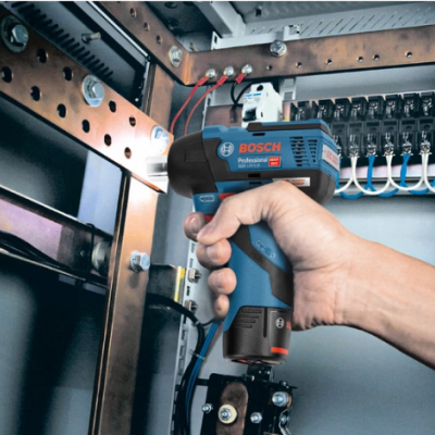 Chave de impacto Bosch Professional a ser usada num painel elétrico.