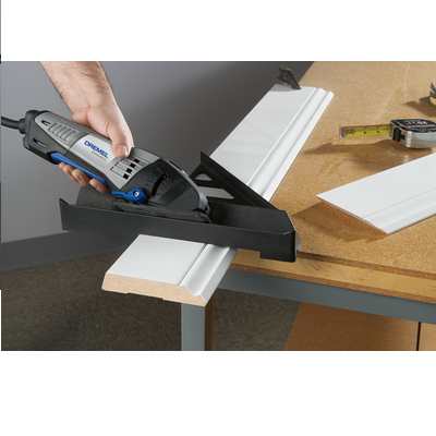 Ferramenta elétrica Dremel a cortar moldura branca na mesa