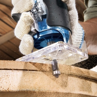 Ferramenta elétrica azul e preta a trabalhar em madeira clara