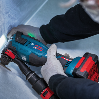 Ferramenta elétrica BOSCH azul e preta com detalhes vermelhos em uso