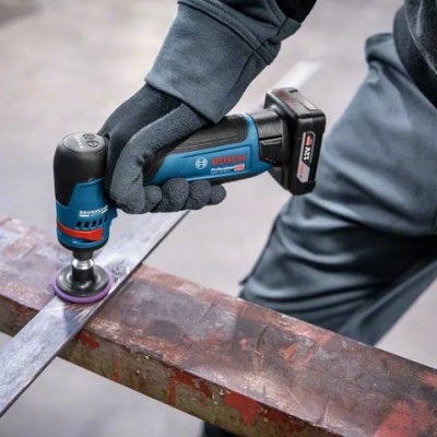 Lixadora Bosch sem fio preta e azul a ser usada numa peça metálica em oficina