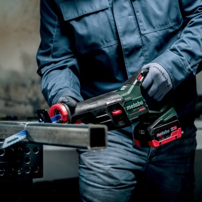 Serra de esquadria elétrica Metabo a cortar tubo metálico numa oficina