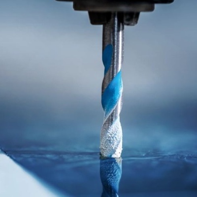 Broca azul e branca a perfurar uma superfície metálica