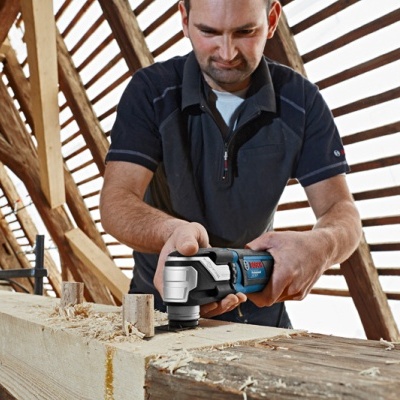 homem a usar ferramenta elétrica multifunções BOSCH num ambiente interior de madeira