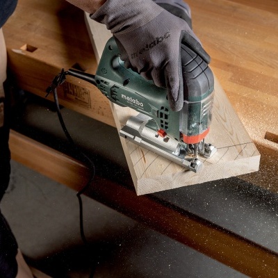 Pessoa a cortar madeira com serra elétrica Metabo numa bancada de madeira