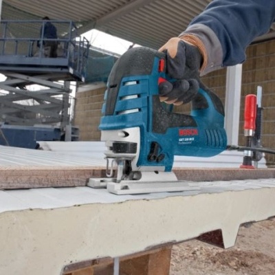 Serra tico-tico azul a cortar madeira numa oficina de construção