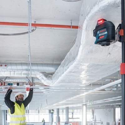 Nível a laser Bosch montado em obra com trabalhador a medir