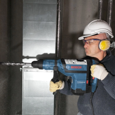 perfurete elétrico Bosch Professional azul com trabalhador usando capacete e proteção auditiva