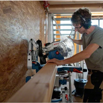 Homem a usar serra Bosch para cortar madeira numa oficina