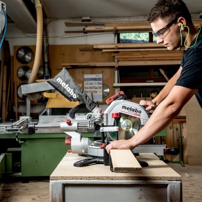 Homem a cortar madeira com máquina Metabo numa oficina