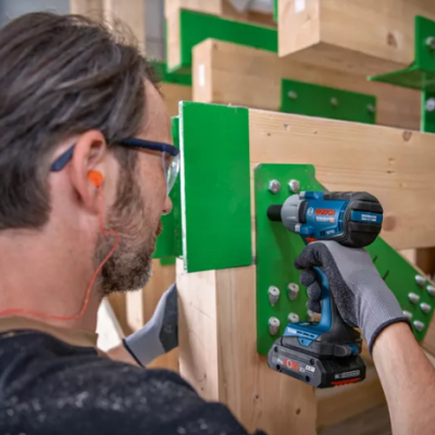 Parafusadeira Bosch a apertar parafusos em estrutura de madeira com suportes verdes