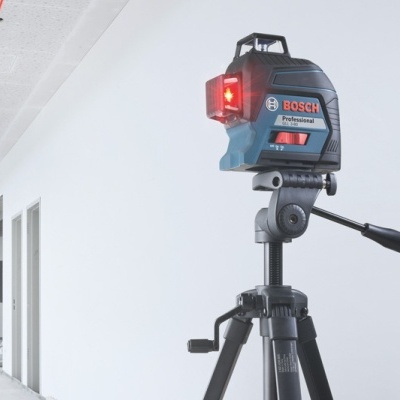 Laser de medição Bosch Professional montado num tripé preto num corredor branco
