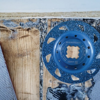 Disco de moagem azul Bosch sobre madeira desgastada com tecidos ao lado