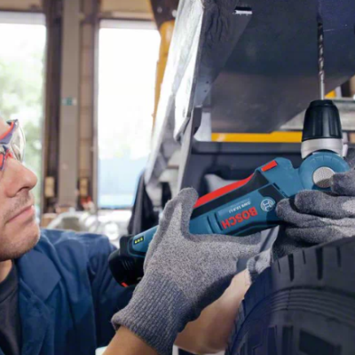 Pessoa usando ferramenta Bosch a trabalhar num pneu de carro numa oficina