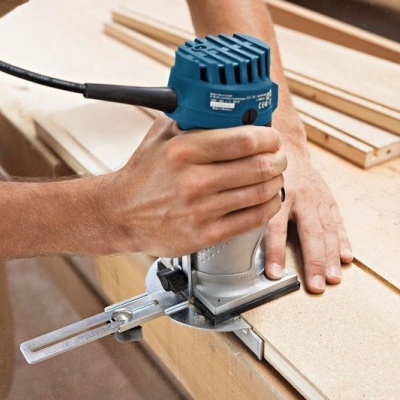 Tupia elétrica azul e cinza a trabalhar em madeira numa bancada de oficina