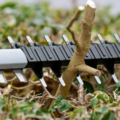 Aparelho de corte para sebes com lâminas metálicas e estrutura plástica em sebe verde
