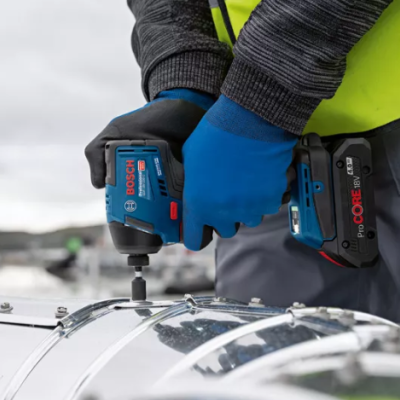 Pessoa usando chave de impacto Bosch azul para apertar parafusos em estrutura metálica