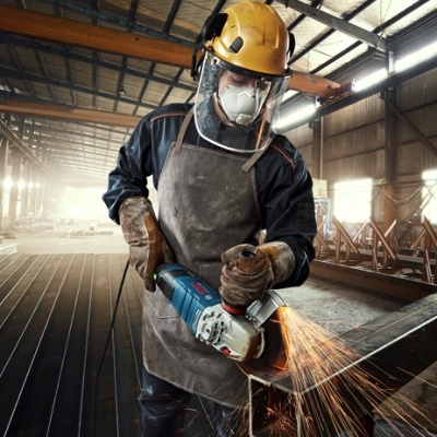 Trabalhador a usar rebarbadora num ambiente industrial