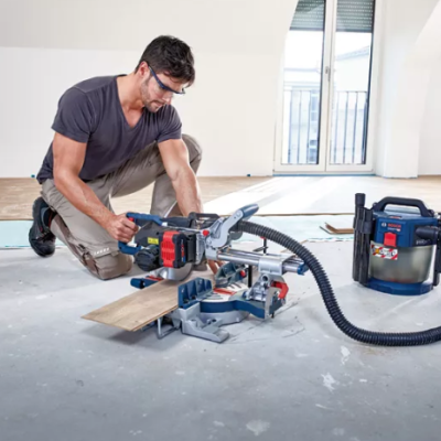 Homem a usar serra elétrica Bosch com aspirador em ambiente interior