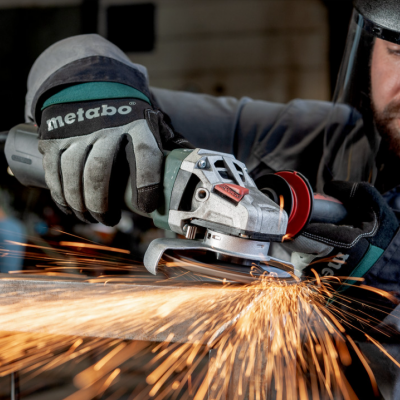 Homem a usar rebarbadora Metabo com luvas e capacete em ambiente industrial