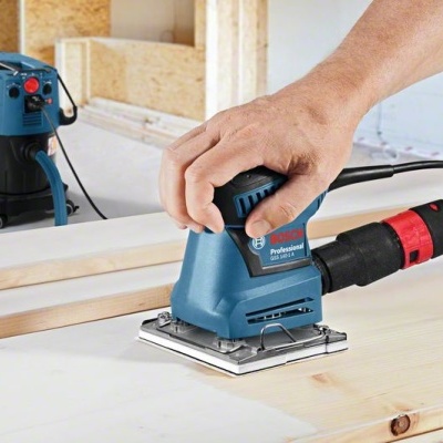 Lixadeira elétrica azul Bosch a trabalhar em madeira clara