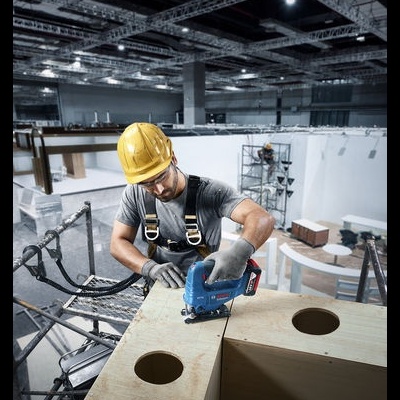 Homem com capacete amarelo a usar serra elétrica BOSCH para cortar madeira