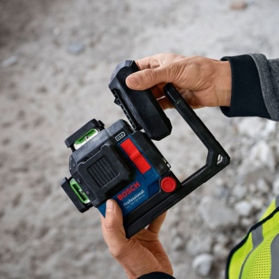 instrumento de medição Bosch azul escuro com detalhes vermelhos e verdes nas mãos de pessoa com colete amarelo