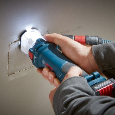 Pessoa a usar ferramenta elétrica para cortar parede