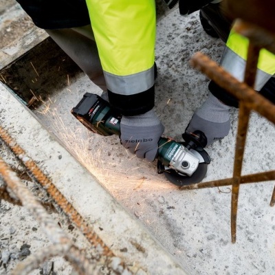 Trabalhador a usar rebarbadora em obra