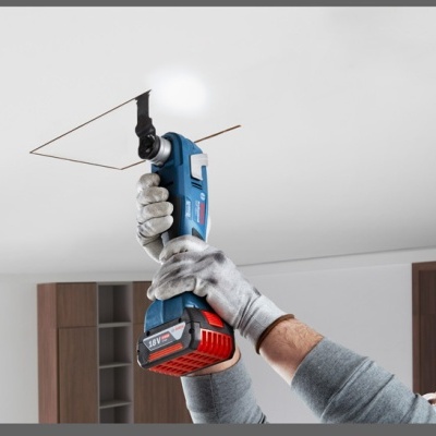 Pessoa usando ferramenta elétrica para trabalho no teto branco