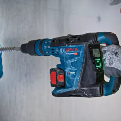 Martelo perfurador Bosch Professional azul e preto em uso numa parede branca