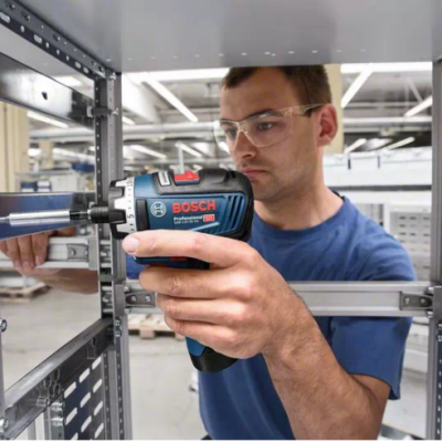 Homem a usar parafusadora elétrica BOSCH num ambiente industrial