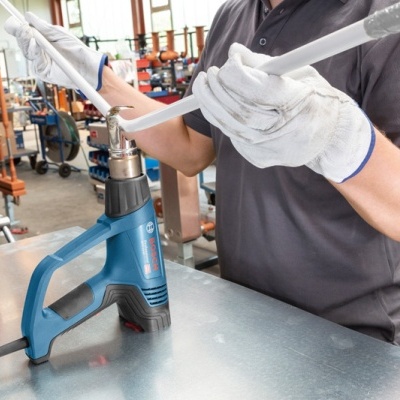 Martelo perfurador azul sobre bancada metálica em ambiente industrial