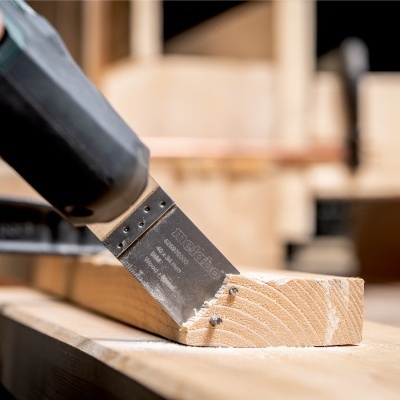 Espátula a raspar madeira clara numa bancada de carpintaria