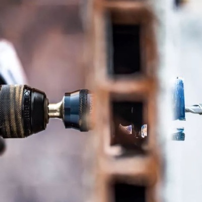 Furadeira eléctrica a perfurar peça de madeira com parafuso