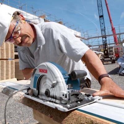 Serra circular Bosch azul e cinza em construção a cortar madeira