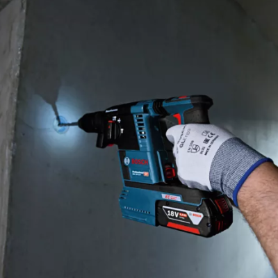 Furadeira Bosch 18V a ser usada numa parede cinzento claro