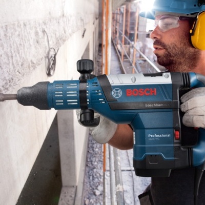 Homem com equipamento de proteção a usar furadeira BOSCH Professional no local de construção