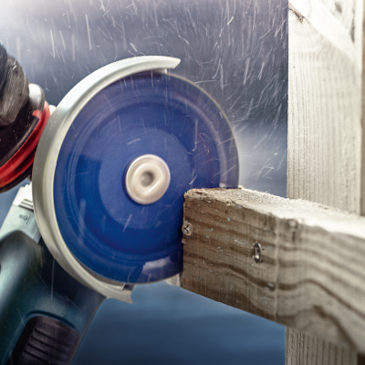 Serra elétrica a cortar madeira com luvas pretas