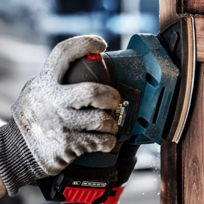 Pessoa a usar lixadeira elétrica para lixar madeira