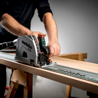 Serra circular Metabo a cortar madeira numa prancha em cavaletes
