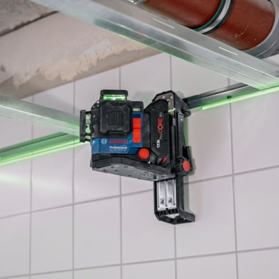 Laser de alinhamento Bosch montado numa parede com azulejos brancos e linhas laser verdes