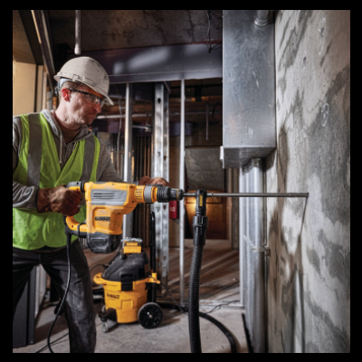 Martelo perfurador elétrico amarelo e preto DEWALT em uso numa parede de obra