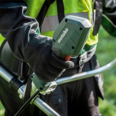 Aparelho de jardinagem Metabo cinza e preto seguro com luvas pretas ao ar livre