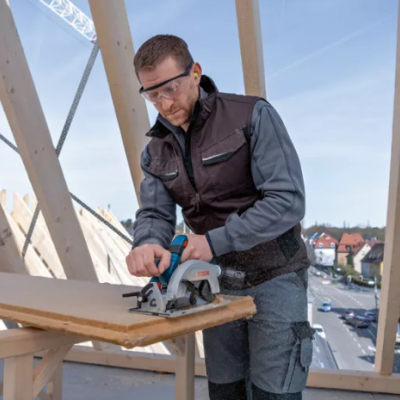 Homem a cortar madeira com serra circular num local de construção