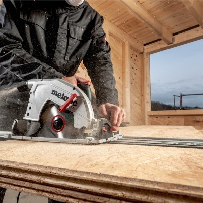 Serra circular Metabo branca e preta em madeira com trabalhador