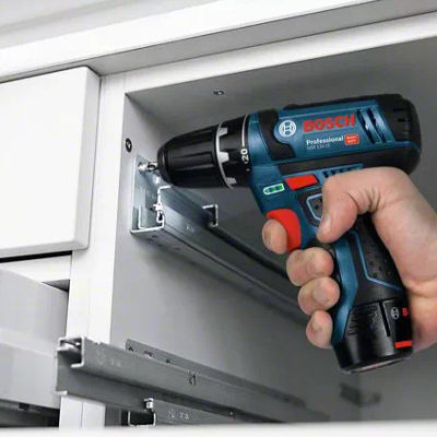 Parafusadeira BOSCH Professional preta e azul sendo usada em cozinha branca moderna