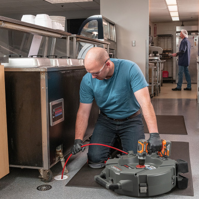 Homem operando máquina de inspeção em cozinha industrial